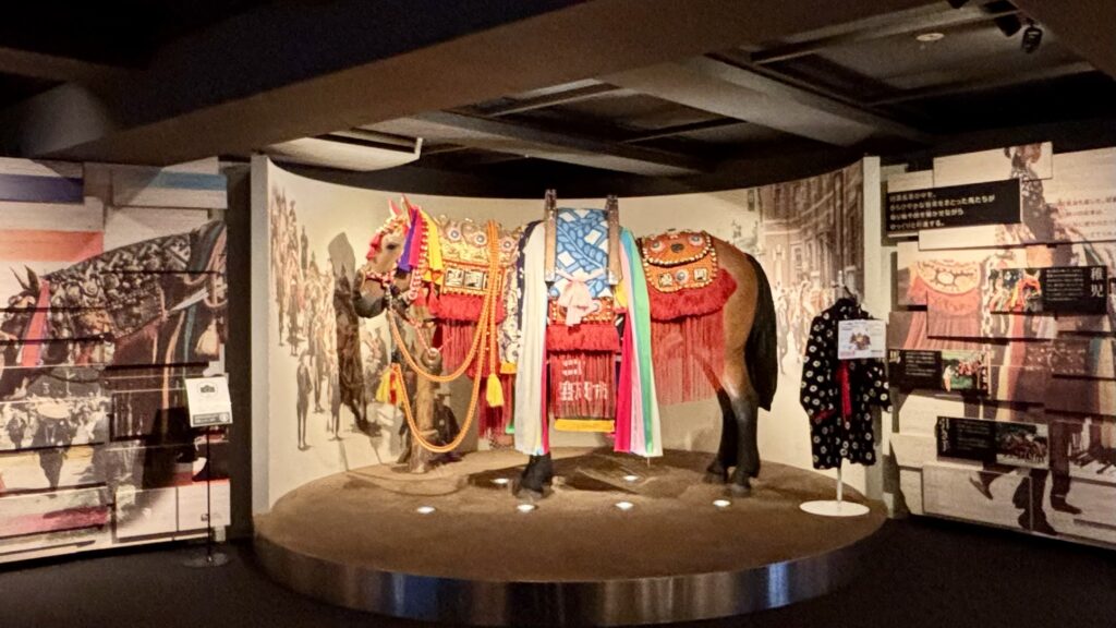 もりおか歴史文化館に展示されている、チャグチャグ馬コの鮮やかな装束をまとった馬の模型

